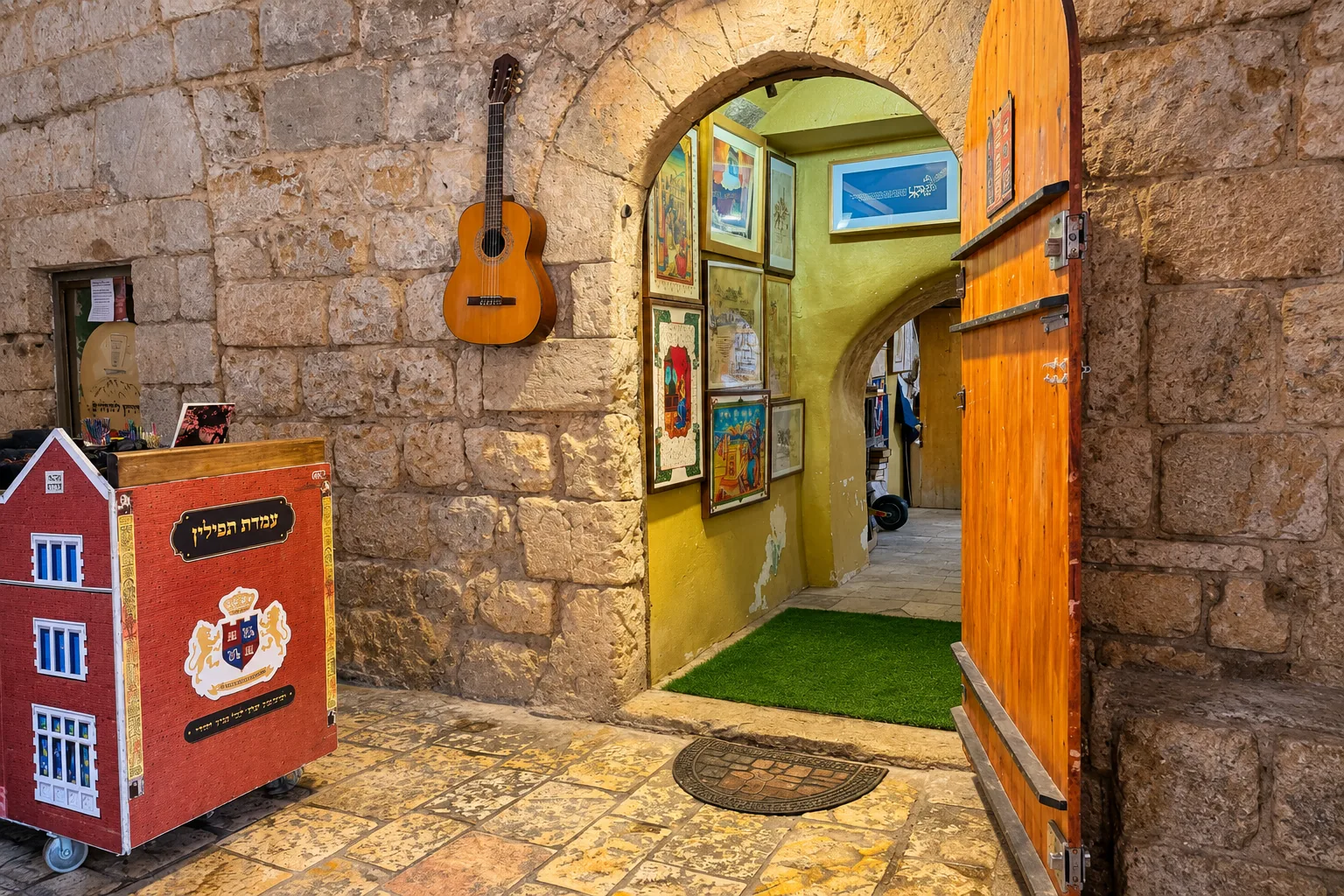הכניסה המקושתת לבית חב״ד, דלת העץ וחלל האירוח שמעבר לה